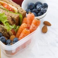 lunch box with sandwich of wholemeal bread on white background, closeup